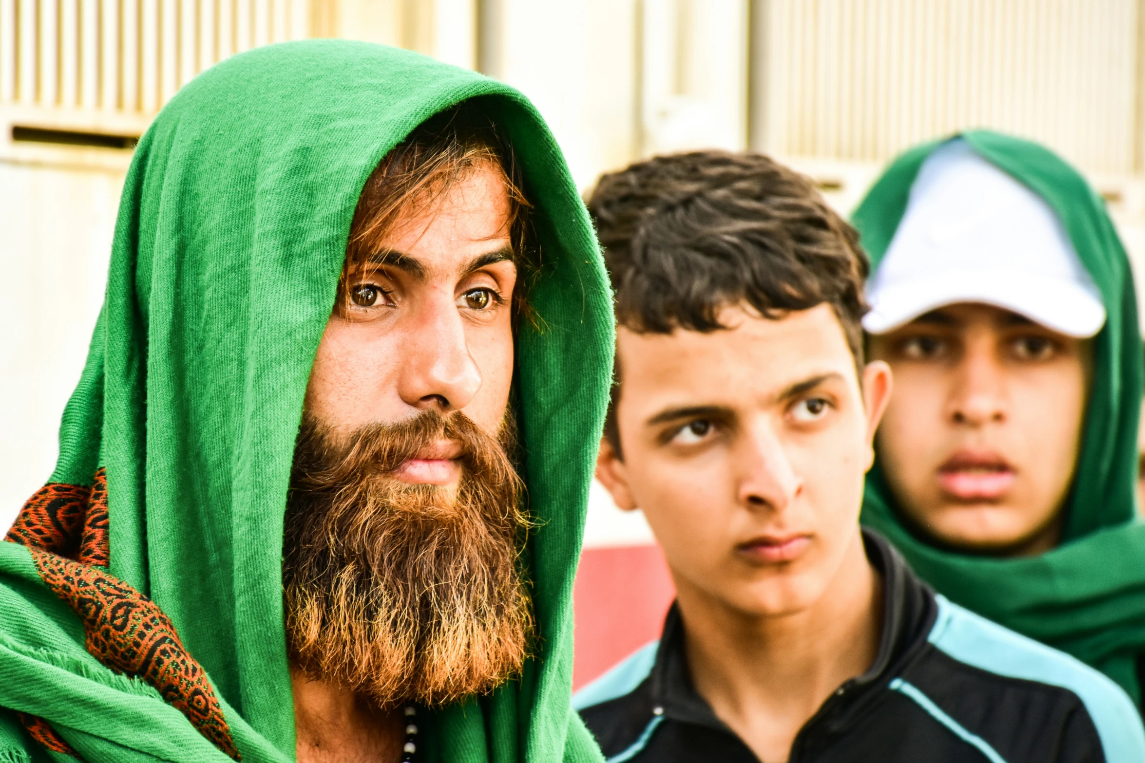 two men are wearing scarves and green hats