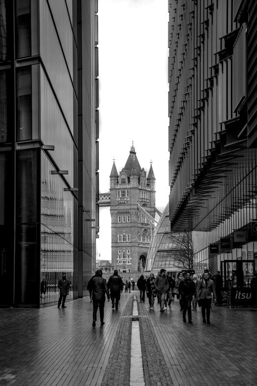 a black and white po of a tower with people walking in front of it