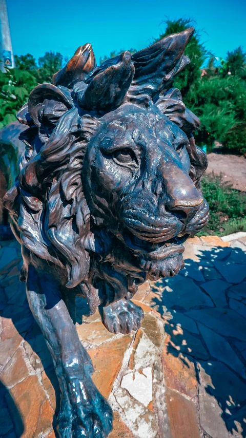 a statue of a lion sitting on top of a brick patio