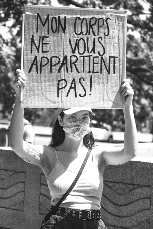 a woman holding a sign with some writing on it