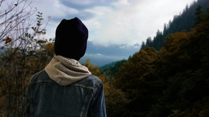 the man is walking along the trail near a wooded area