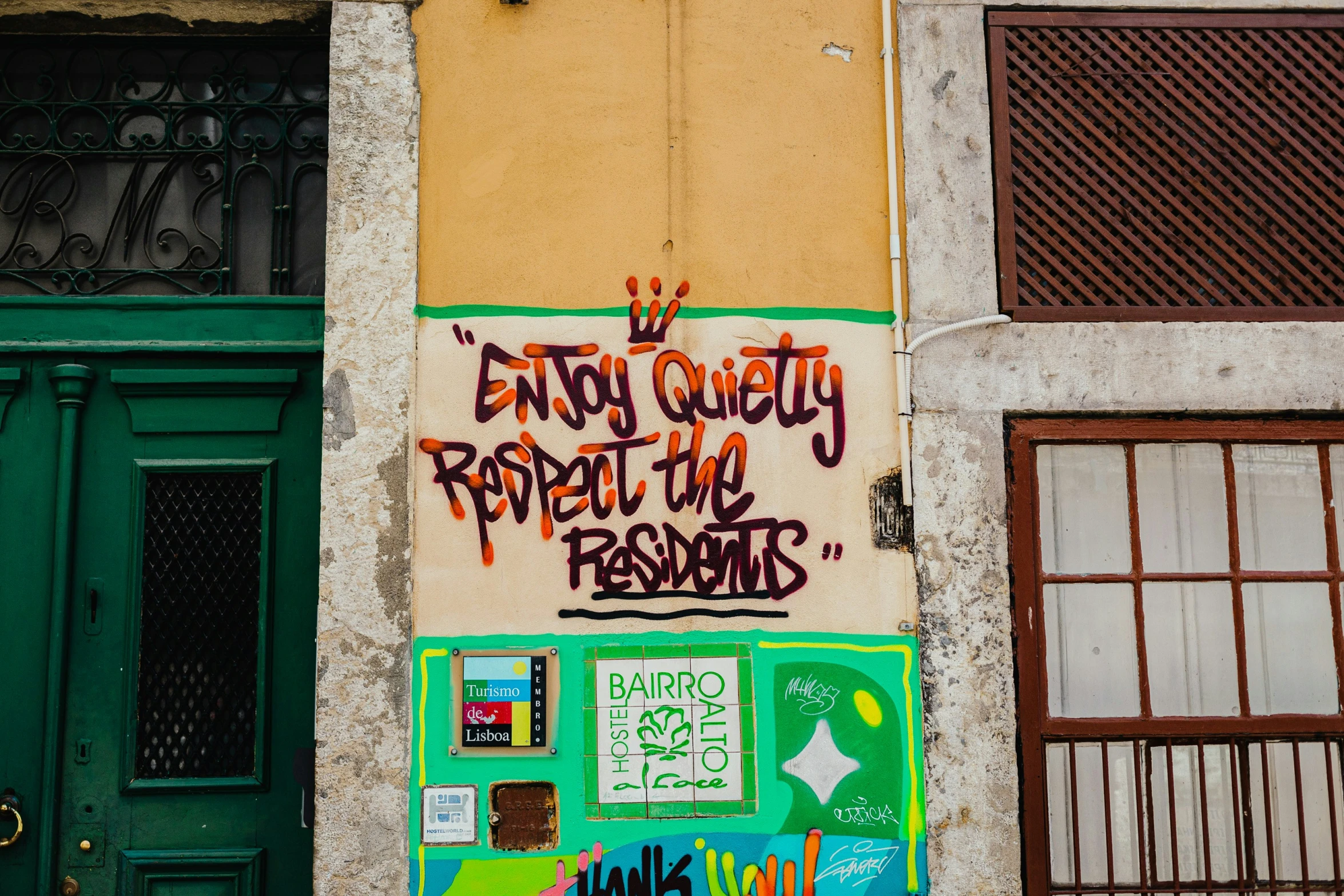 a bunch of graffiti writing on a wall near a building