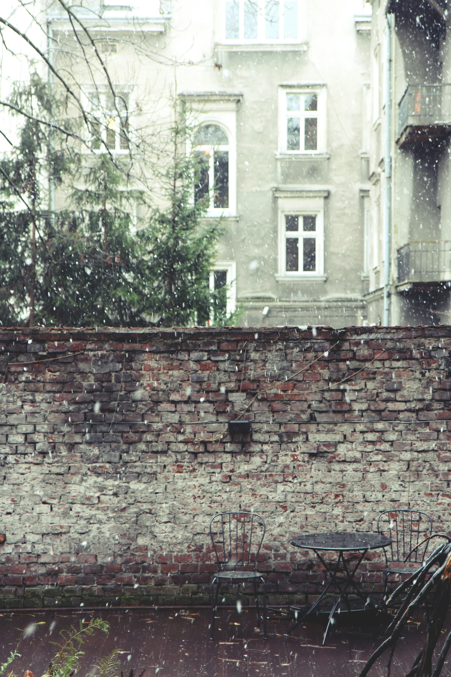 a bicycle is parked against a wall on a rainy day