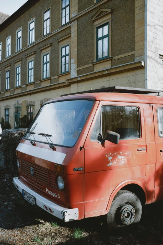 a red van sitting outside of a tall building