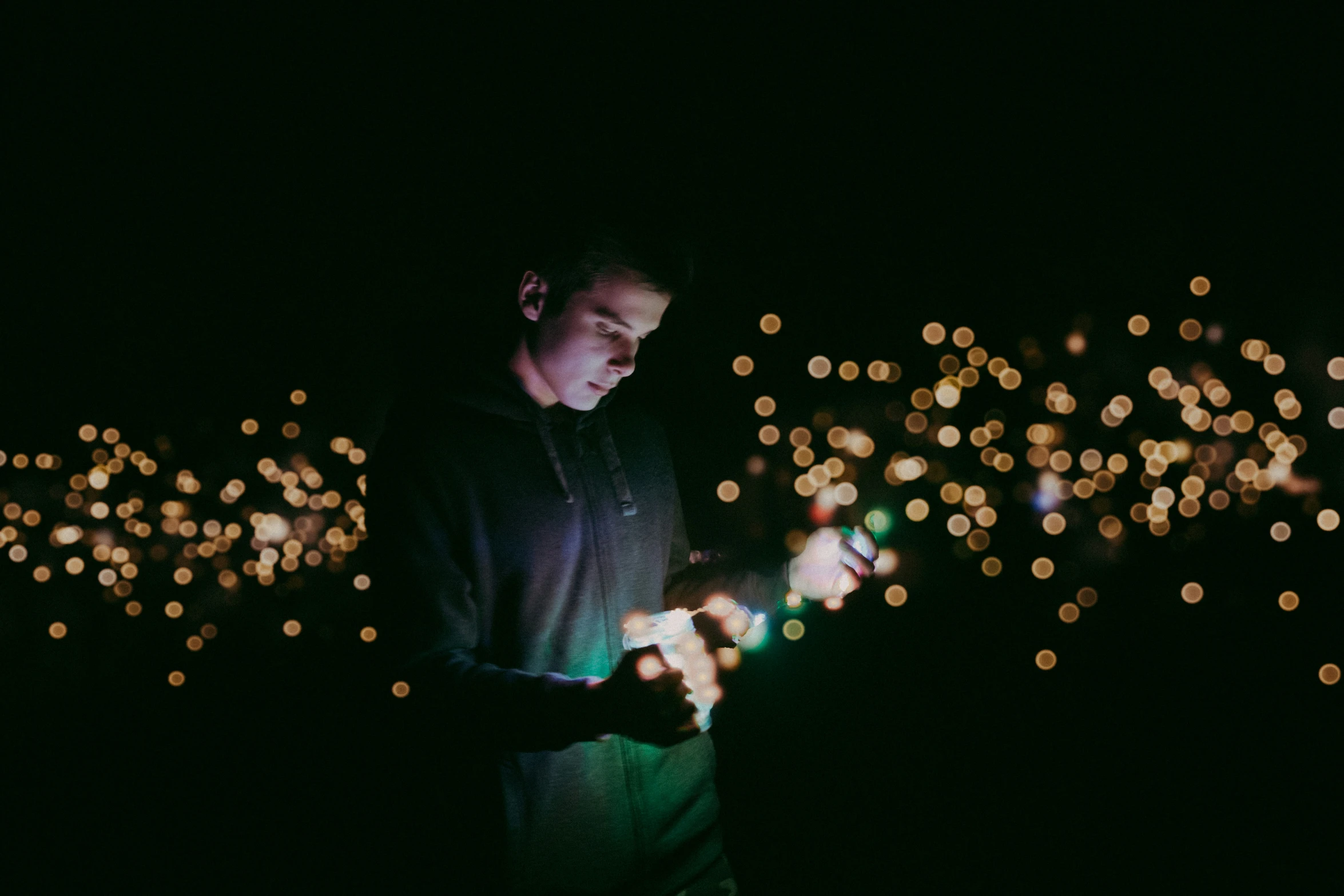 a man looking at soing with blurry lights behind him