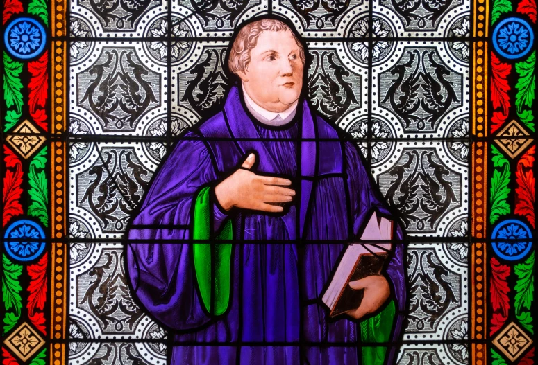 stained glass of a person holding a book