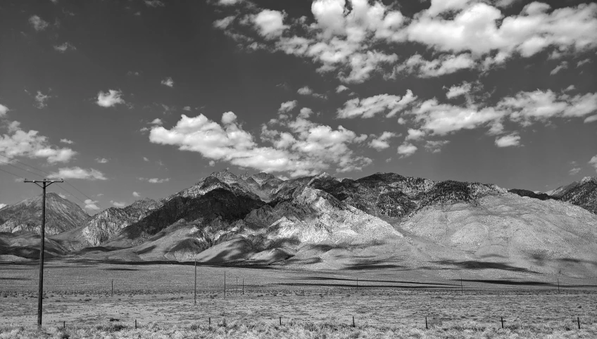 an empty field with many large mountains in the background