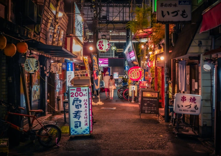 an alley lined with stores lit up at night