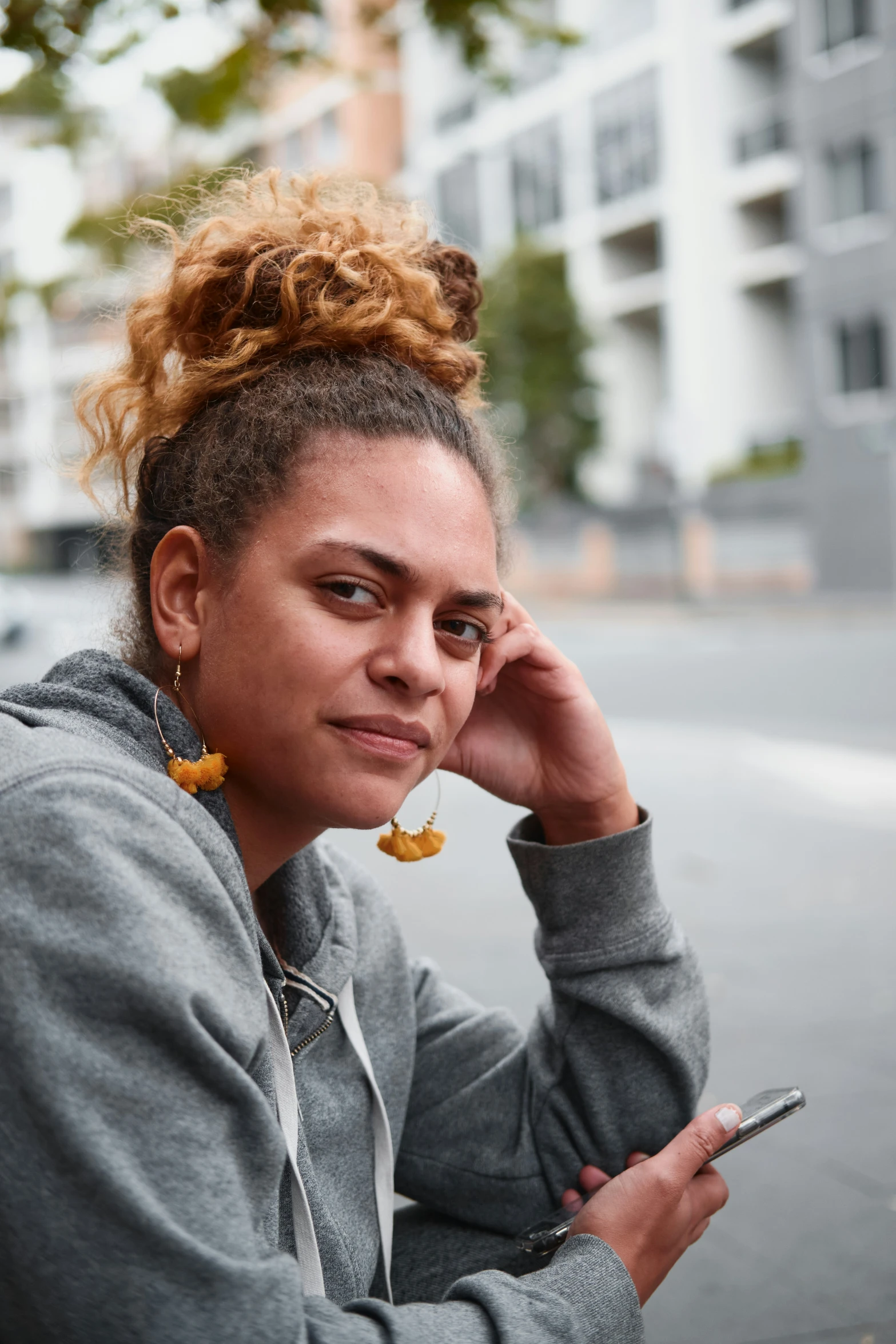 a woman holding her cell phone by the sidewalk