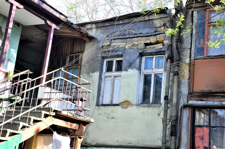 an old building with a balcony, shutters and steps