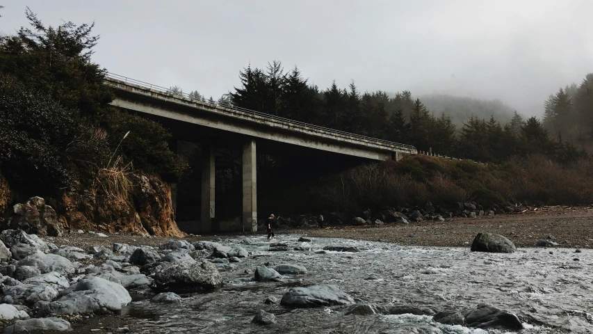 there is a bridge over a river that has water rushing under it