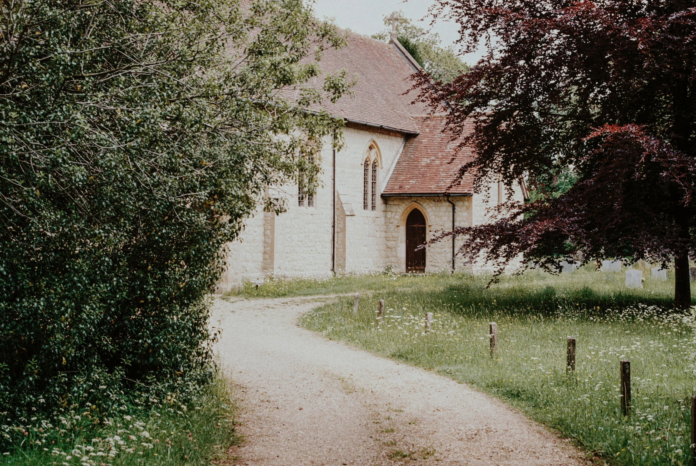 a house sitting in the middle of a green field