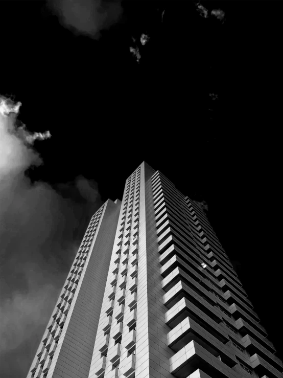 a tall building towering above clouds in the sky