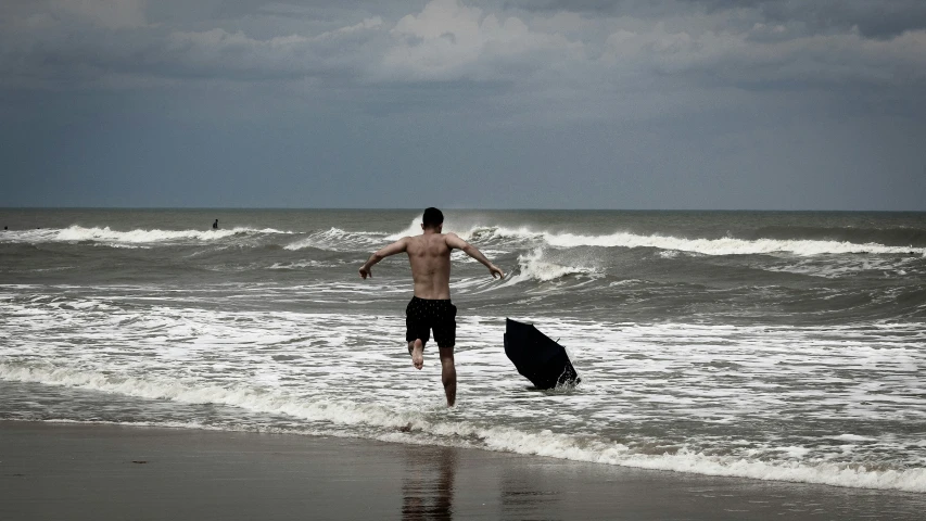 a person in the water at a beach with a surfboard