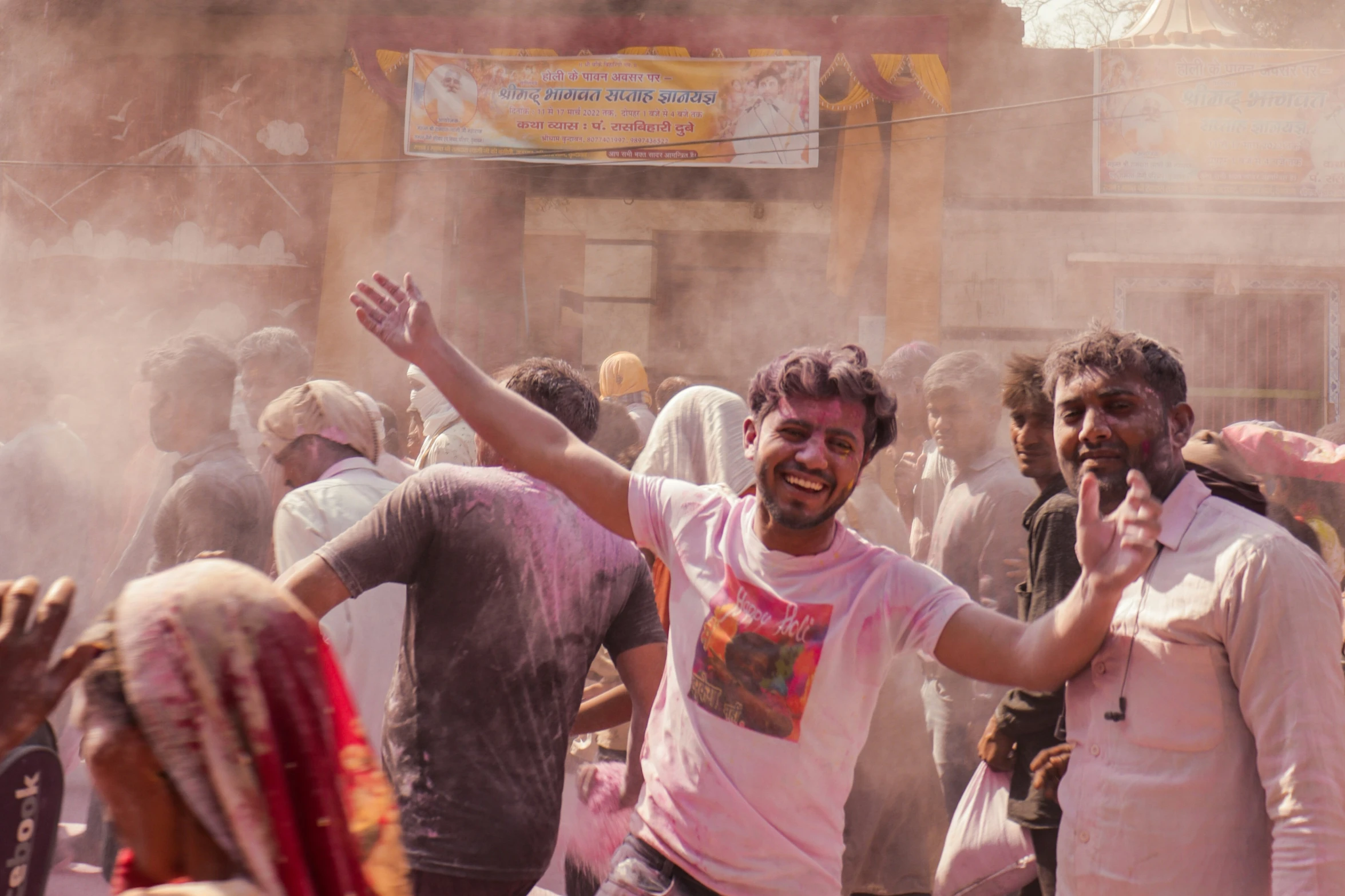 a man in white and pink is celeting outside