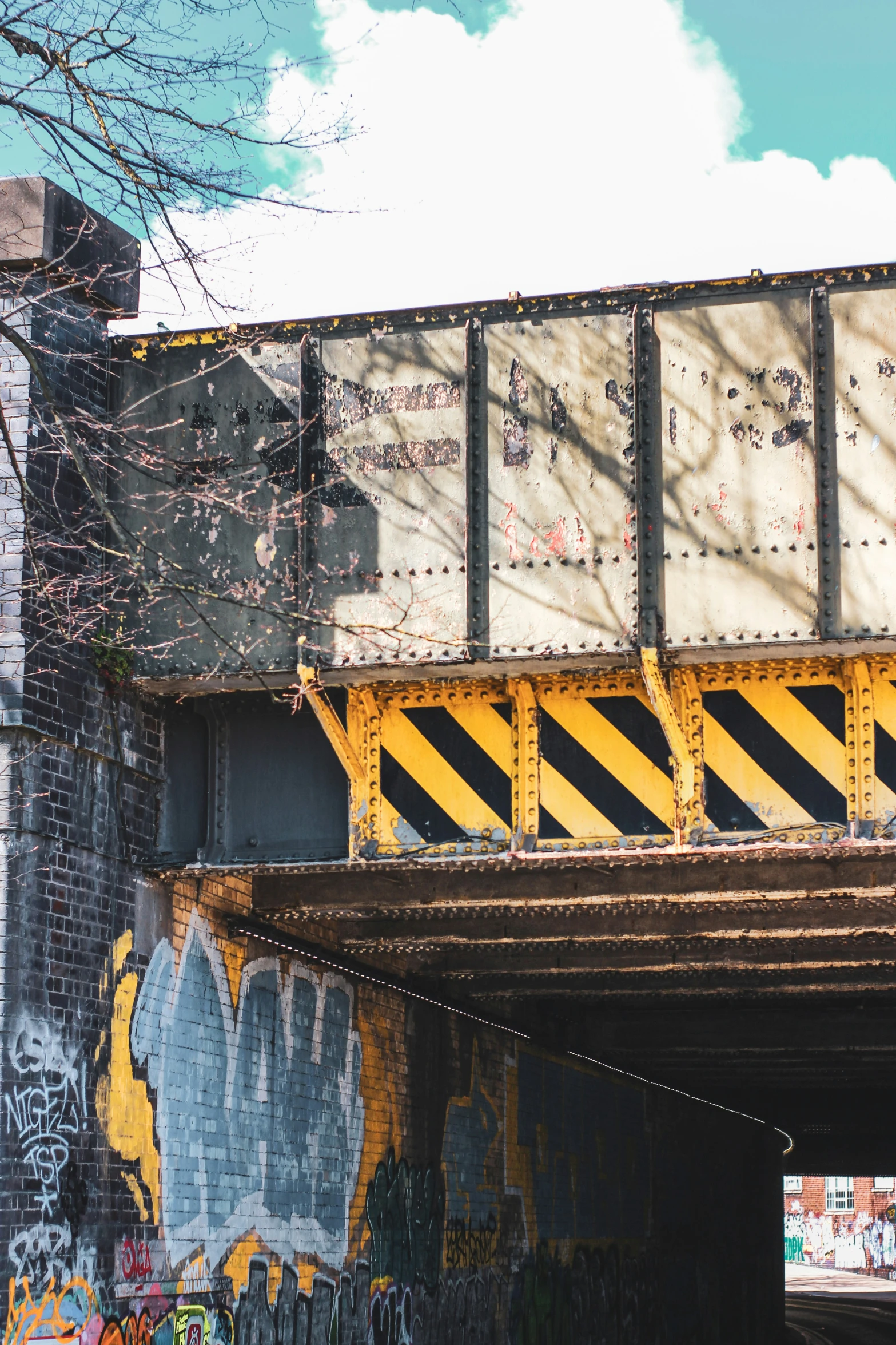 graffiti on a yellow and black striped section of an underpass