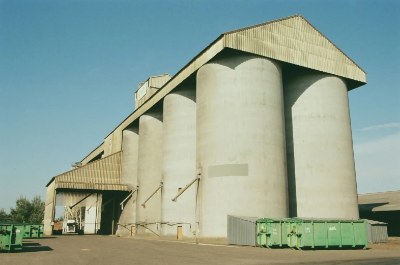two silos sitting in front of a large concrete building
