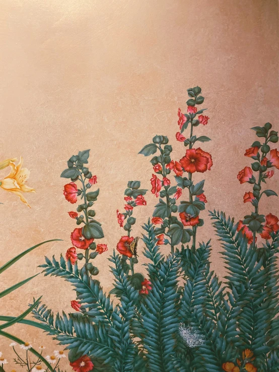 a painting with red flowers and leaves on a tan wall