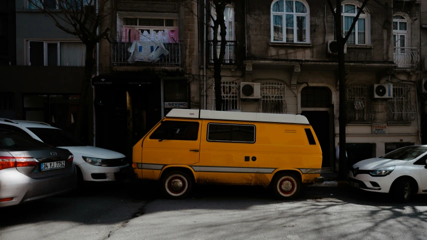 an orange van is parked next to a silver car