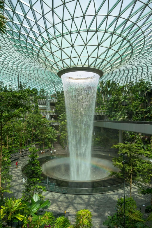 there is a huge glass plant ceiling in the center of this garden