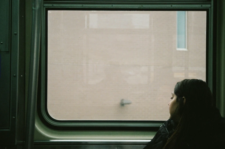 a woman looking out a window on a train