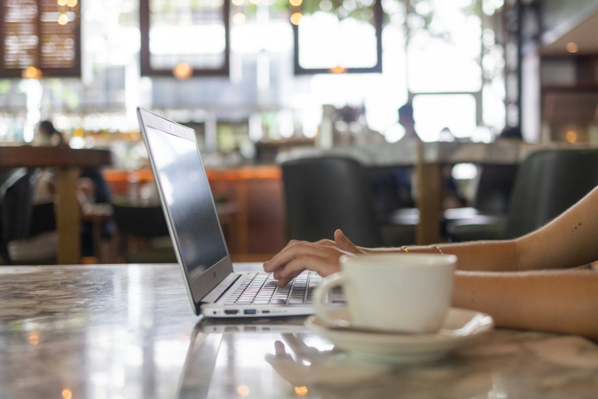 a woman is working on her laptop on the table