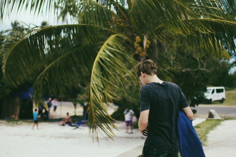 a man is walking near a palm tree