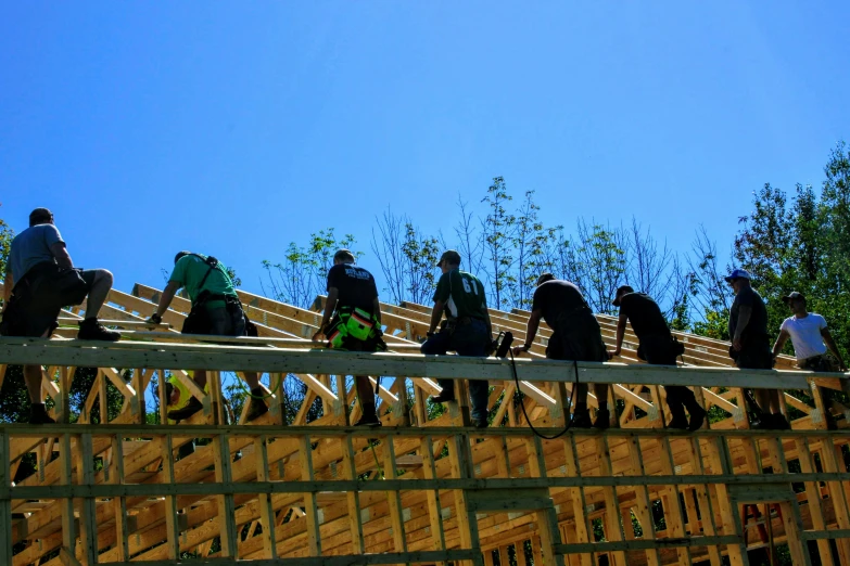 a group of people carrying surfboards across a wooden bridge