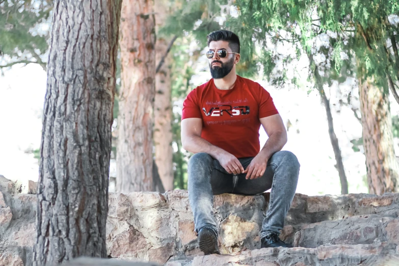 a man sitting on rocks in the woods