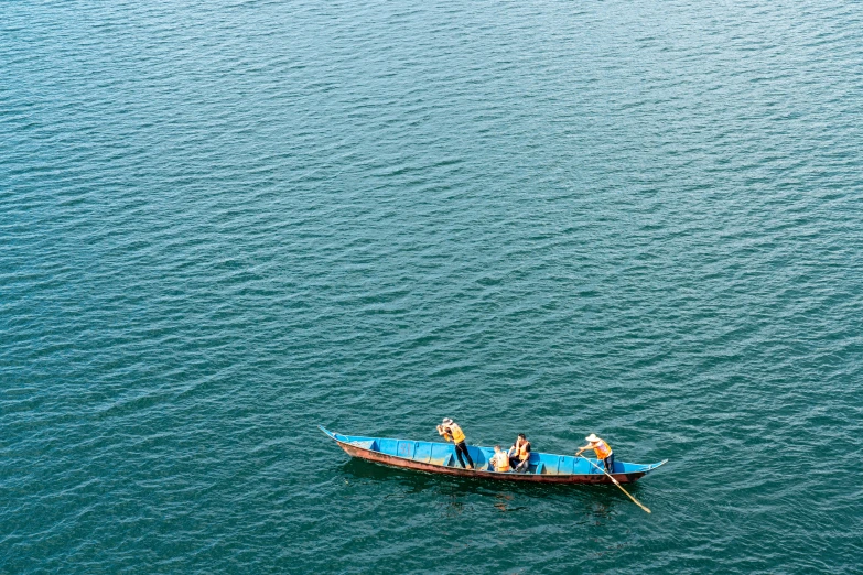 three people are in the boat on the water