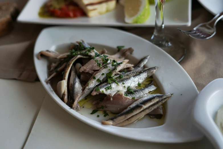 a white plate topped with fish covered in parsley