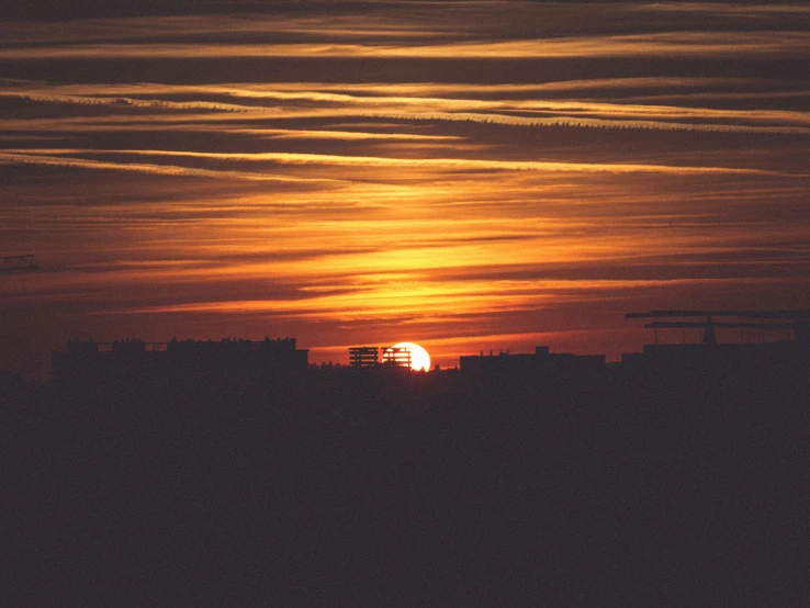 the sun setting on a clear day in the middle of the ocean