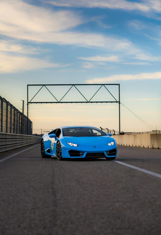 the blue sports car is parked at the end of a road