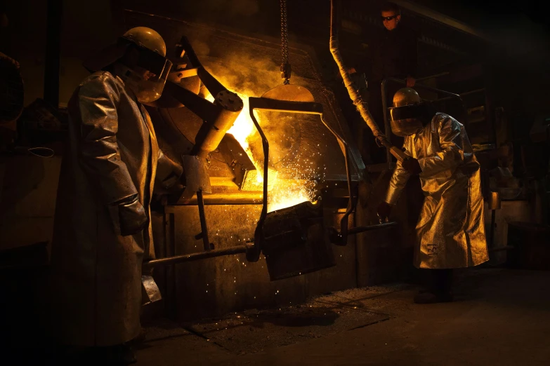 a group of workers using some type of metal machine