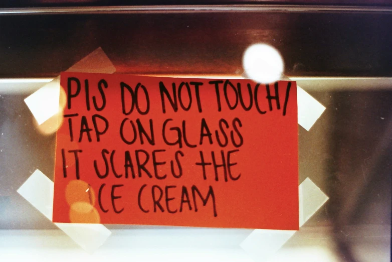 an orange sign sitting on top of a metal shelf