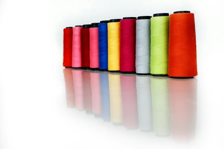 many spools of thread are lined in bright colors