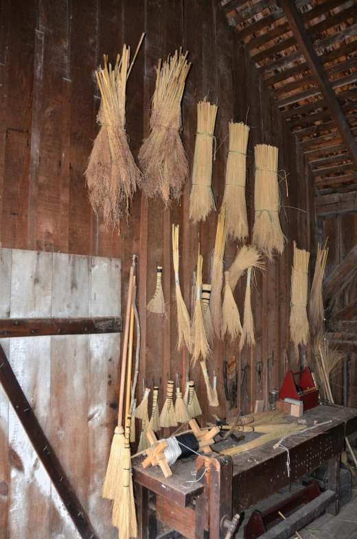 some brooms hanging from a ceiling in a wooden building