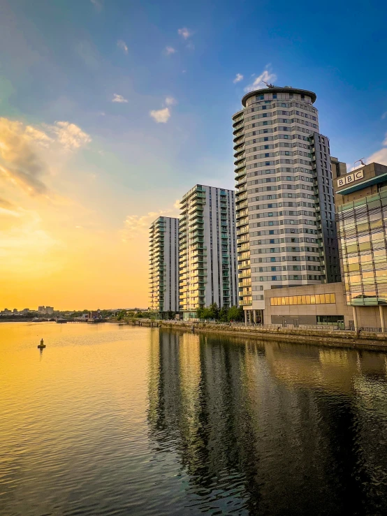 a lake and several buildings by it at sunset