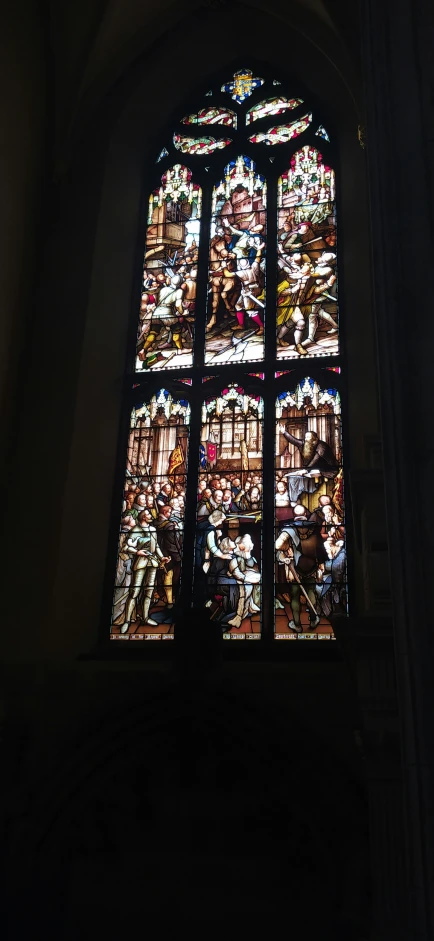 an old stained glass window with images on the glass