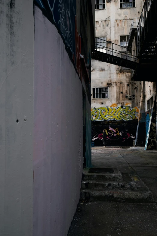 a skateboarder doing a trick on a ramp in an alley