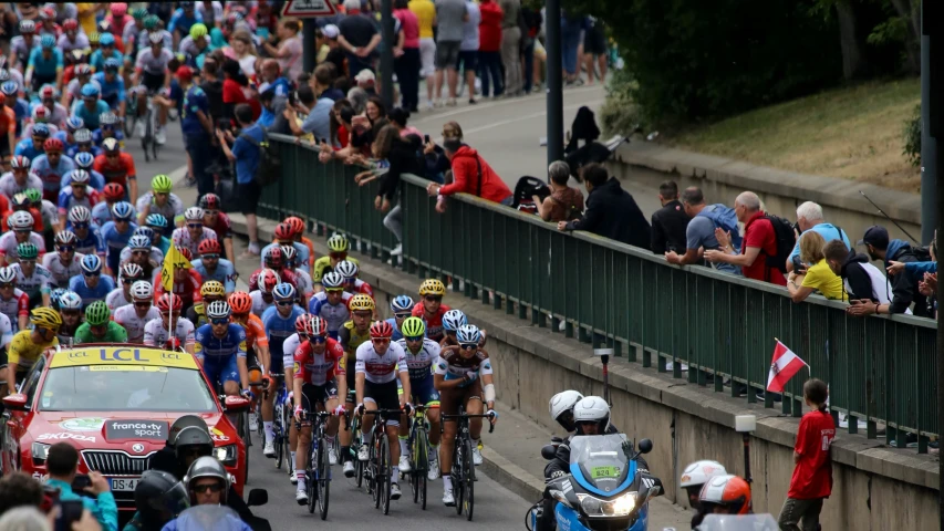 a large group of bicyclists travel on a busy street