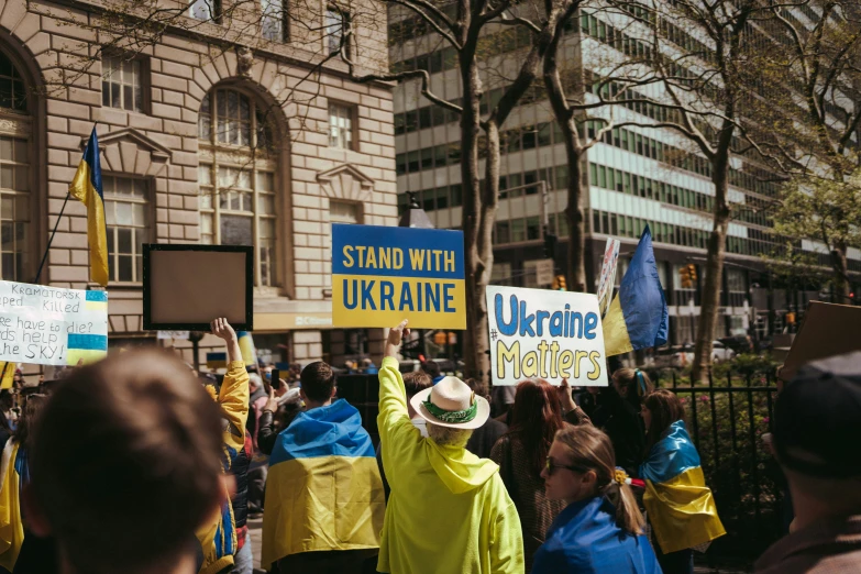 a group of people standing outside a building with yellow jackets