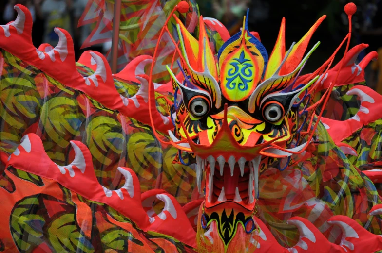 an elaborate asian mask with colorfully decorated feathers