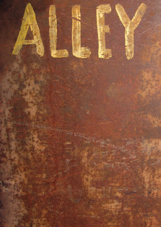 the word alley on a rusted surface with yellow paint