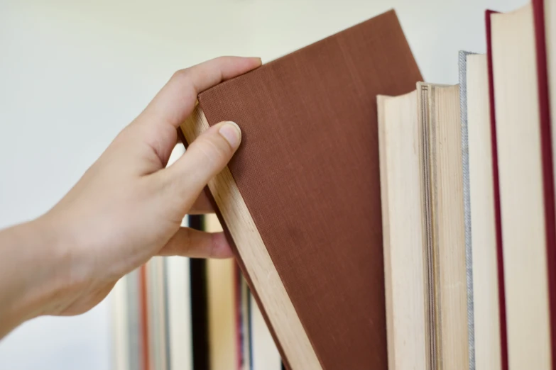 someone is putting an orange book on top of a book