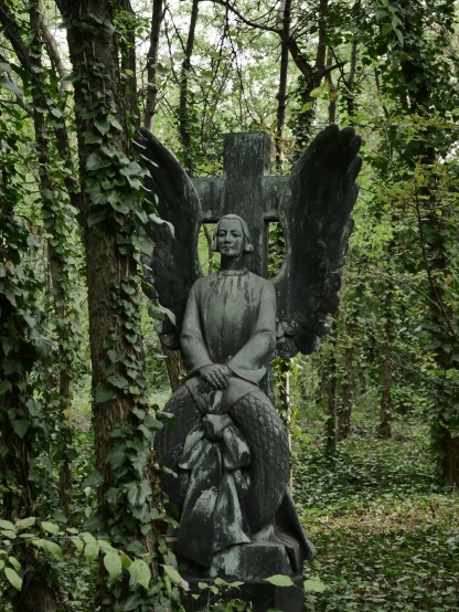 a statue with wings sits in the middle of an outdoor park