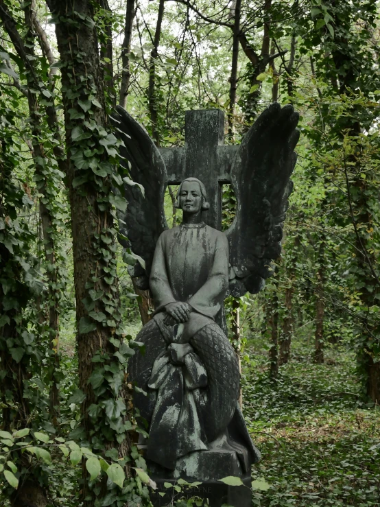a statue with wings sits in the middle of an outdoor park