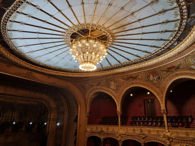 a dome shaped ceiling in a theatre surrounded by red seats