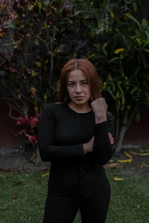 a woman standing in a yard posing for a po