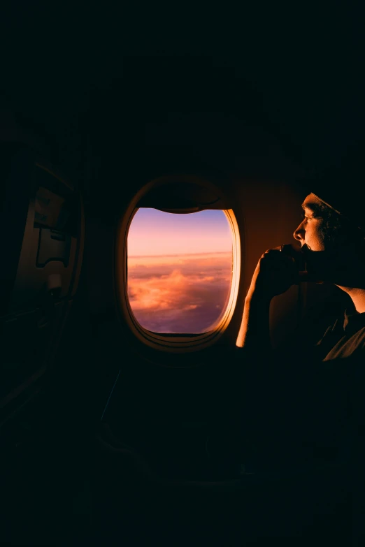 a man sitting looking out an airplane window